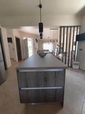 a kitchen with a island in the middle of a living room at Villa Agapi in Pastida