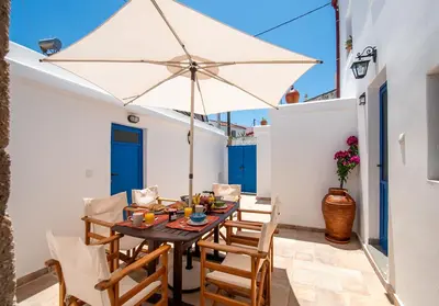 a dining room with a table and an umbrella at Villa Gennadi Essence in Gennadi