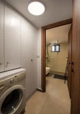 a bathroom with a washing machine and a toilet at Villa Gennadi Essence in Gennadi