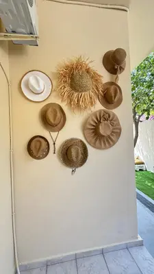 a wall with different types of hats on it at Hidden Lemons - Boho stay in Rhodes in Rhodes Town