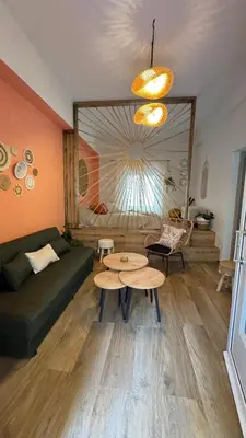a living room with a green couch and a table at Hidden Lemons - Boho stay in Rhodes in Rhodes Town