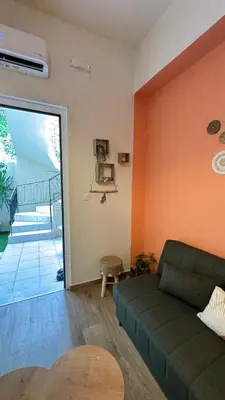 a living room with a green couch and a sliding glass door at Hidden Lemons - Boho stay in Rhodes in Rhodes Town