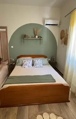 a bedroom with a large bed with a green headboard at Hidden Lemons - Boho stay in Rhodes in Rhodes Town