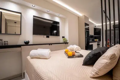 a bedroom with a bed with a television on the wall at Monte Smith Luxury Suites in Rhodes Town
