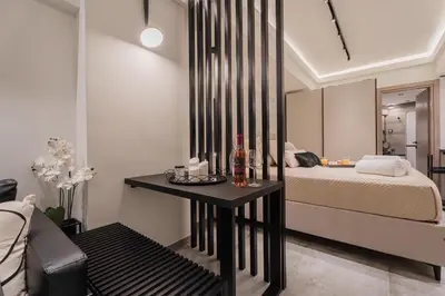 a bedroom with a bed and a table with a mirror at Monte Smith Luxury Suites in Rhodes Town