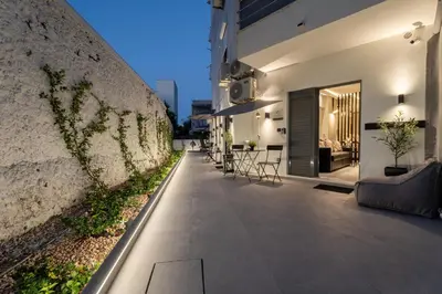 a courtyard of a building with chairs and a wall at Monte Smith Luxury Suites in Rhodes Town