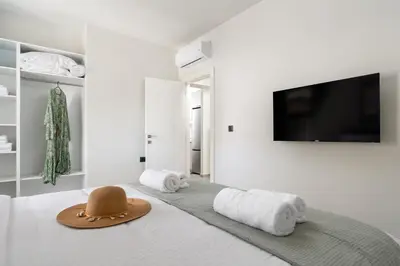 a hat sitting on top of a bed with towels at Duo Verde Soil Garden Apartment in Kremasti