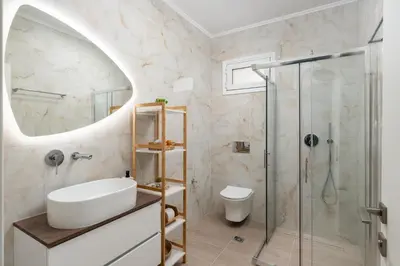 a bathroom with a sink and a shower at Duo Verde Soil Garden Apartment in Kremasti