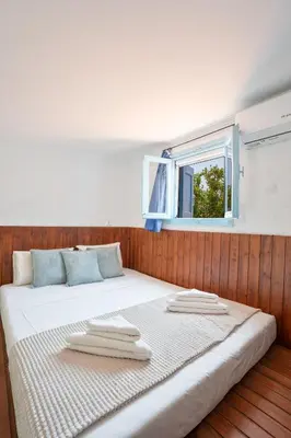 a bed with towels on top of it with a window at 1944-Heritage House in Lardos