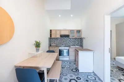 a kitchen with a wooden table and blue chairs at 1944-Heritage House in Lardos