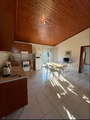 a kitchen with a table in the middle of a room at Aparment in a country house in Ialyssos