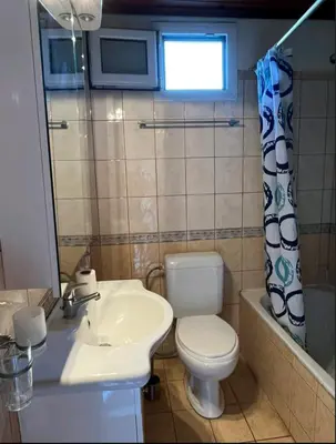 a bathroom with a white toilet and a sink at Aparment in a country house in Ialyssos