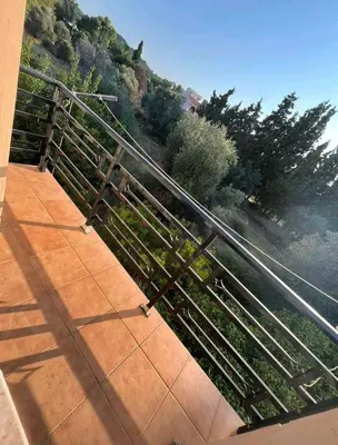 a metal railing on a walkway next to a hill at Aparment in a country house in Ialyssos