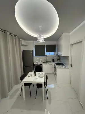 a white table and chairs in a kitchen with a chandelier at Clementine Stay Rhodes - CAR RENTAL AVAILABLE in Rhodes Town