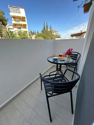 a small table on a balcony with two chairs at Clementine Stay Rhodes - CAR RENTAL AVAILABLE in Rhodes Town
