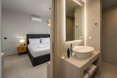 a bathroom with a sink and a bedroom with a bed at Terra Magna Villas in Kiotari