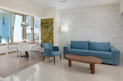 a living room with a blue couch and a table at Celestial City Suite in Rhodes Town