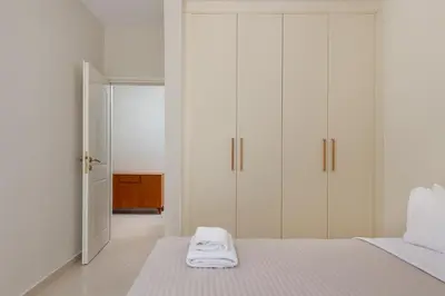 a white bedroom with white cabinets and a bed at Celestial City Suite in Rhodes Town