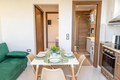a living room with a table and a green couch at Nikargy Avra in Koskinou