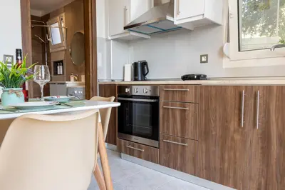 a kitchen with wooden cabinets and a stove top oven at Nikargy Avra in Koskinou