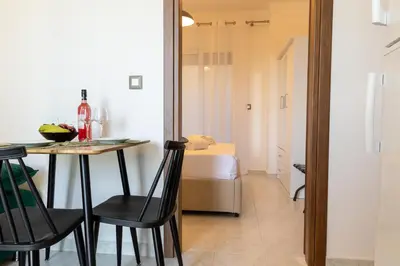 a dining room with a table and chairs and a bed at Nikargy Avra in Koskinou
