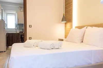 a bedroom with a large white bed with towels on it at Nikargy Avra in Koskinou
