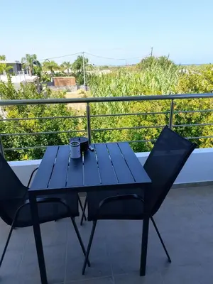 a blue table and two chairs on a balcony at LiRa in Kremasti