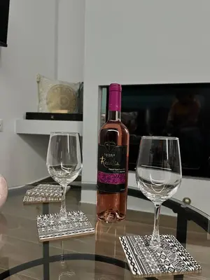 a bottle of wine sitting on a table with two wine glasses at Charavgi House in Archangelos