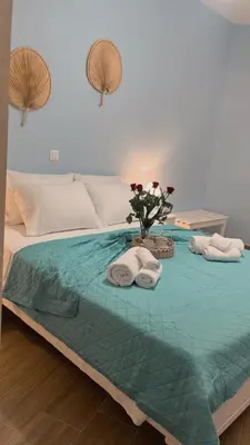 a bed with towels and a vase of flowers on it at Charavgi House in Archangelos