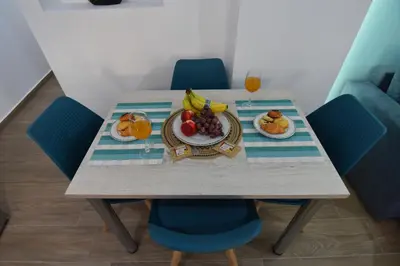 a table with a plate of fruit and a glass of orange juice at Charavgi House in Archangelos