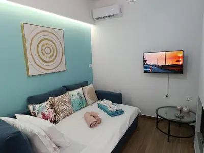 a bedroom with a white bed with a table at Charavgi House in Archangelos