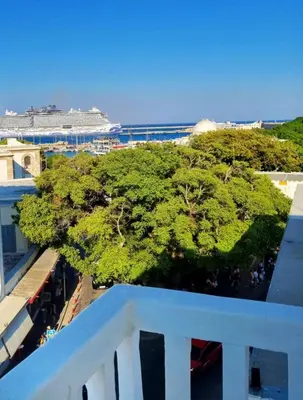 a view of the ocean from a balcony with a cruise ship at Rhodes Port Stories in Rhodes Town
