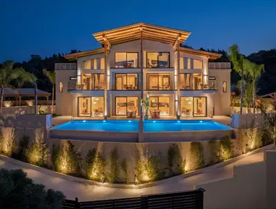 a large house with a lit up facade at night at Costas Luxury Villas - Costa's Villa in Koskinou