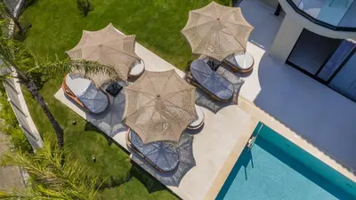 an overhead view of a patio with umbrellas next to a pool at Costas Luxury Villas - Costa's Villa in Koskinou