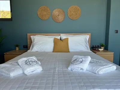 a bed with towels and pillows on it at Aelios Petra sea view apartment 4 in Asgourou