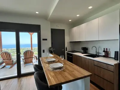 a kitchen with a table with two glasses on it at Aelios Petra sea view apartment 4 in Asgourou