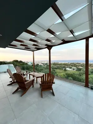a patio with chairs and a table on a roof at Aelios Petra sea view apartment 4 in Asgourou