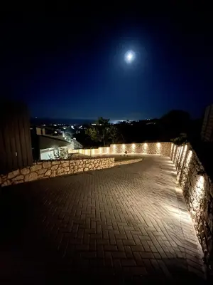 a night view of a walkway with a moon at Aelios Petra sea view apartment 4 in Asgourou