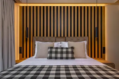 a bedroom with a bed with a checkered blanket at Costas Luxury Villas - Athena's Villa in Koskinou