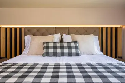a bed with a black and white checkered blanket and pillows at Costas Luxury Villas - Athena's Villa in Koskinou