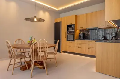a kitchen and dining room with a wooden table and chairs at Costas Luxury Villas - Athena's Villa in Koskinou