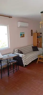 a bedroom with a bed and a table and a window at Giannis Valeria in Rhodes Town
