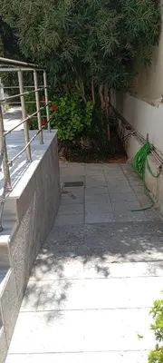 a concrete walkway next to a building with a fence at Giannis Valeria in Rhodes Town