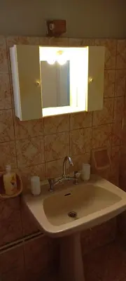 a bathroom sink with a mirror and a light above it at Giannis Valeria in Rhodes Town