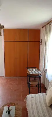 a living room with a table and a cabinet at Giannis Valeria in Rhodes Town