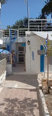a white building with a blue door and a staircase at Giannis Valeria in Rhodes Town