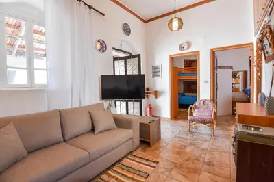 a living room with a couch and a flat screen tv at Casa La Perla - Lachania in Lachania