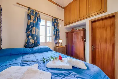 a bedroom with a blue bed with a flower on it at Casa La Perla - Lachania in Lachania