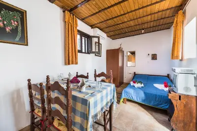a bedroom with a table and a bed in a room at Casa La Perla - Lachania in Lachania