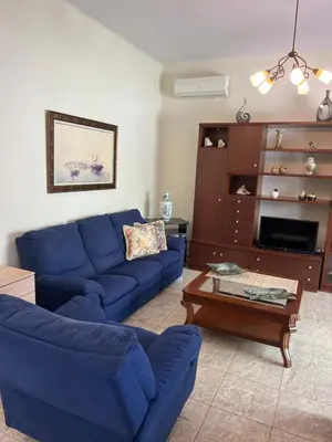 a living room with a blue couch and a coffee table at Cozy Kolonaki Retreat in Kremasti